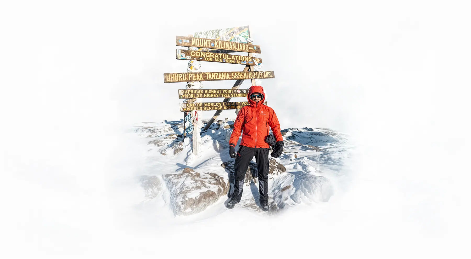 Climber at the Uhuru Peak summit sign on Mount Kilimanjaro Climber at the Uhuru Peak summit sign on Mount Kilimanjaro